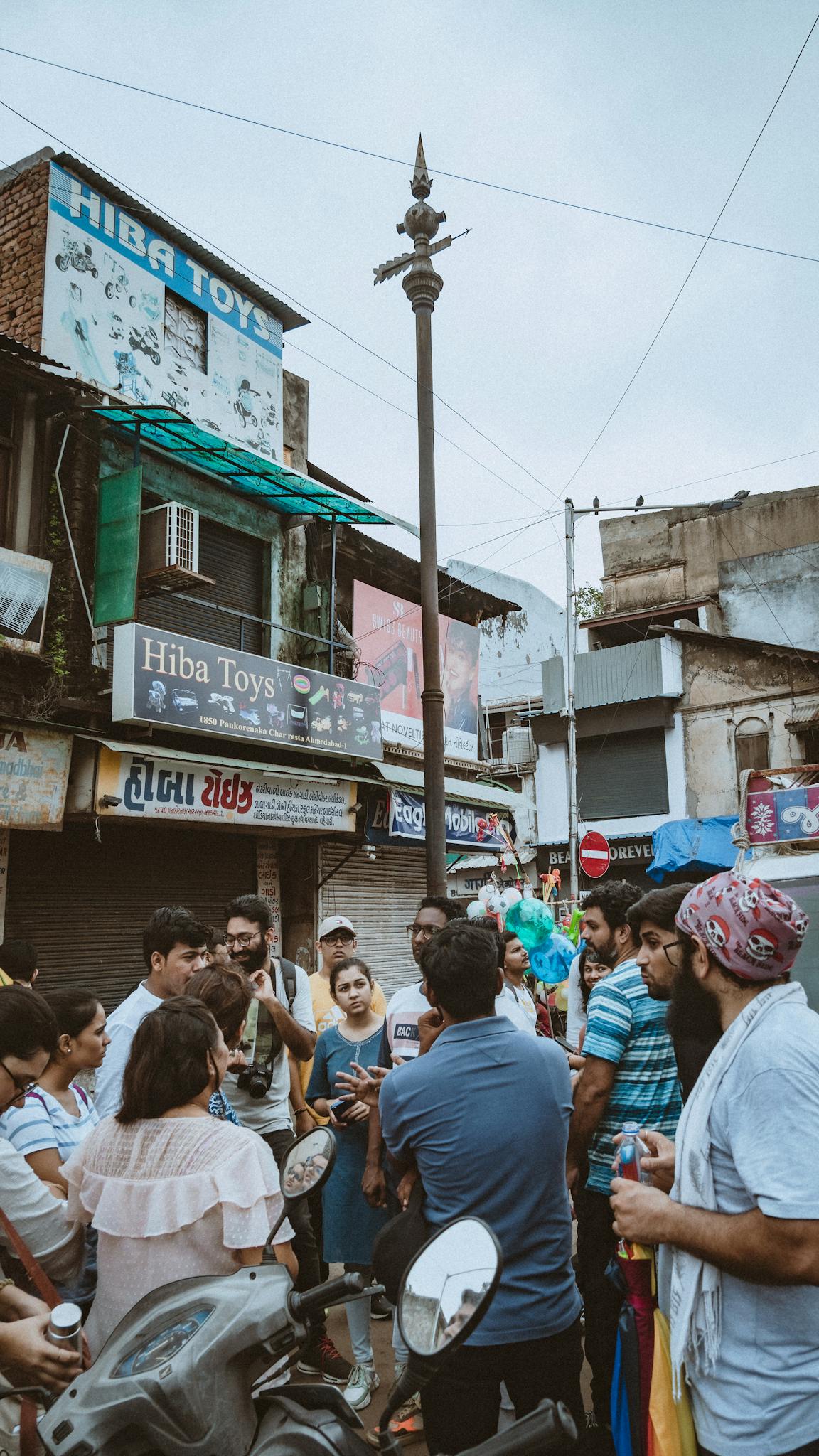 A diverse group of people gathered on a busy urban street, showcasing cultural vibrancy.