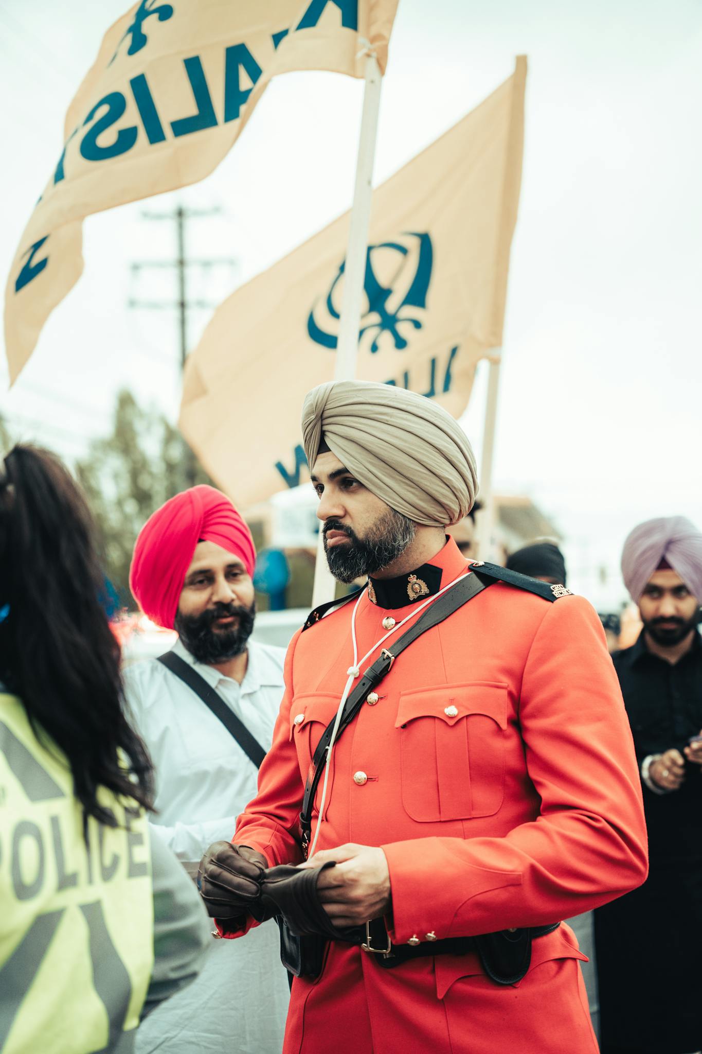 A vibrant gathering of people in traditional turbans and uniforms at an outdoor event.